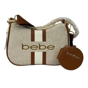 NWT, still in its packaging. She is a Bebe Crossbody purse. Caramel/beige color.
